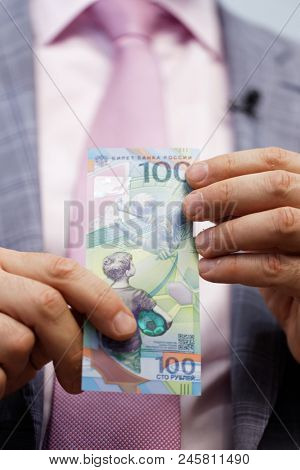 ST. PETERSBURG, RUSSIA - MAY 23, 2018: General director of JSC Goznak Arkady Trachuk shows the commemorative banknote for FIFA World Cup 2018 in the exhibition 