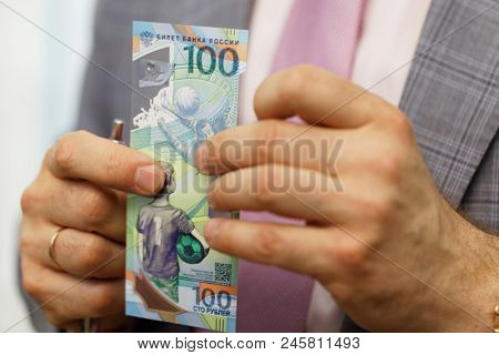 ST. PETERSBURG, RUSSIA - MAY 23, 2018: General director of JSC Goznak Arkady Trachuk shows the commemorative banknote for FIFA World Cup 2018 in the exhibition 