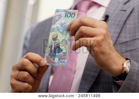 ST. PETERSBURG, RUSSIA - MAY 23, 2018: General director of JSC Goznak Arkady Trachuk shows the commemorative banknote for FIFA World Cup 2018 in the exhibition 