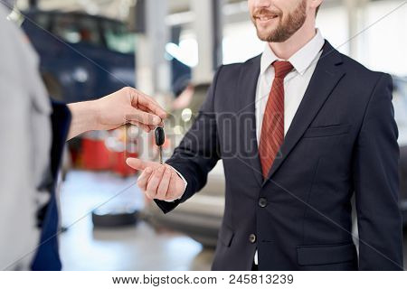 Mid Section Portrait Of Smiling Handsome Businessman Taking Car Keys While Standing In Production Wo