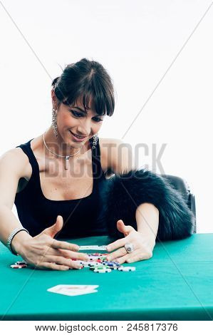 Young Caucasian Brunette Playing Poker At The Green Table. Studio Shot