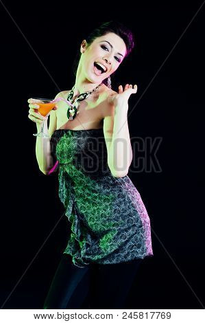 Young Caucasian Brunette Taking Aperitif With Black Background. Studio Shot