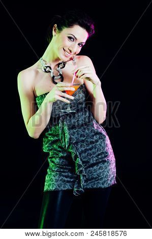 Young Caucasian Brunette Taking Aperitif With Black Background. Studio Shot