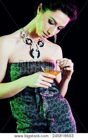 Young Caucasian Brunette Taking Aperitif With Black Background. Studio Shot