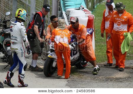 SEPANG, Malezja - 22 października: utwór personel pomoże MotoGP jeździec Karel Abrahama po jego rower utknęły w martwym punkcie