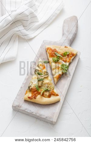 Two Pieces Of Cheese Pizza On White Cutting Board.