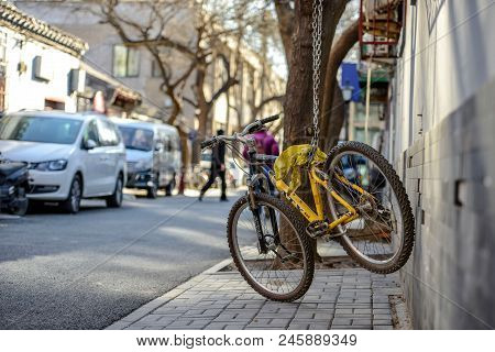 Beijing, China - March 10, 2016: Bicycles, Scooters And Cars In Beijing Streets. A Yellow Bike Is Co