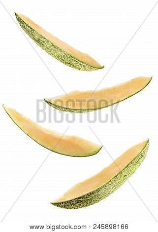 Creative Concept With Flying Melon. Sliced Four Pieces Of Melon Isolated On White Background. Levity