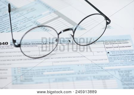 Us Tax Form And Glasses. Finance Concept