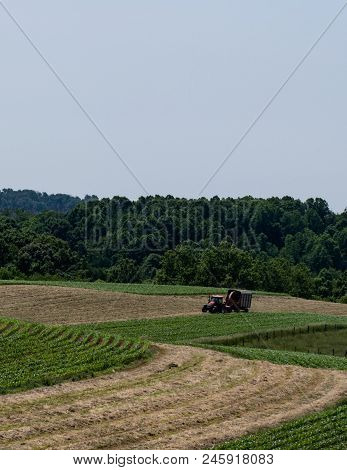 Agricultural Background Of A Dairy Farmer Harvesting Haylage On Rolling Hill Fields In Appalachia - 