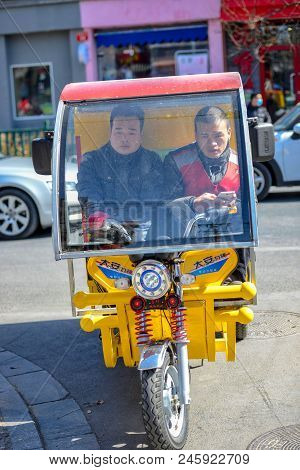 Beijing, China - March 10, 2016: People Are Driving Through The Streets With Bicycles, Scooters And 