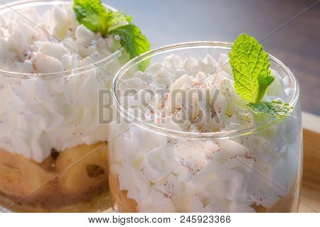 Banoffee Pie In A Cup.banoffee Decorated With Mint Leaves Placed In A Wooden Tray With Meal Served.