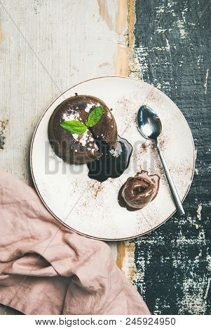 Flat-lay Of Hot Chocolate Souffle Dessert Cake With Liquid Filling And Chocolate Ice Cream Over Rust