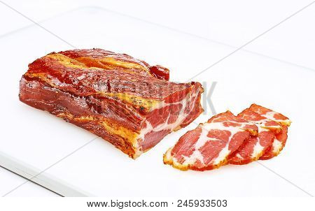 A Piece Of Meat Balyk With A Crust Of Spices And Sesame Seeds On A Cutting Board