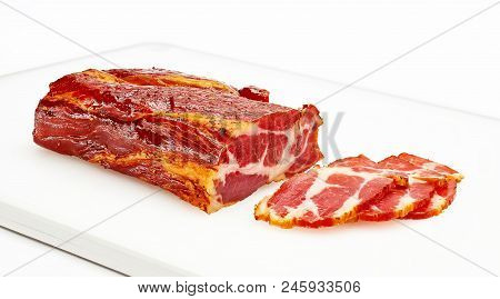 A Piece Of Meat Balyk With A Crust Of Spices And Sesame Seeds On A Cutting Board