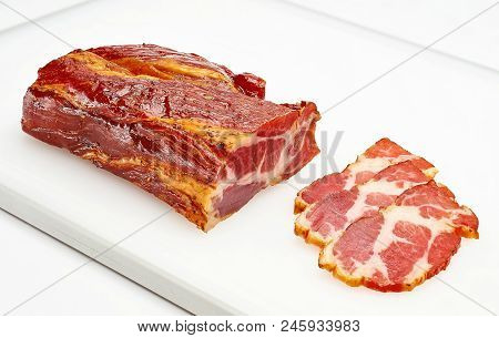 A Piece Of Meat Balyk With A Crust Of Spices And Sesame Seeds On A Cutting Board