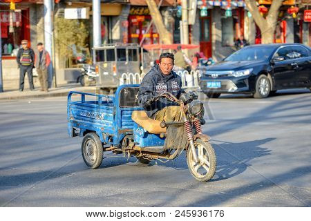 Beijing, China - March 11, 2016: People Are Driving Through The Streets With Bicycles, Scooters And 