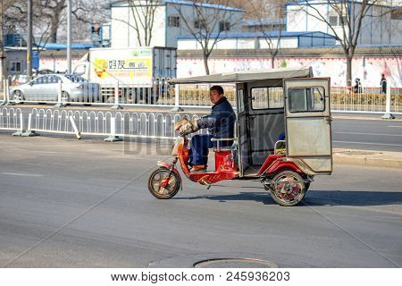 Beijing, China - March 14, 2016: People Are Driving Through The Streets With Bicycles, Scooters And 
