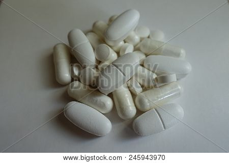 Fistful Of White Magnesium Citrate Capsules, Calcium Citrate Caplets And Vitamin K2 Tablets