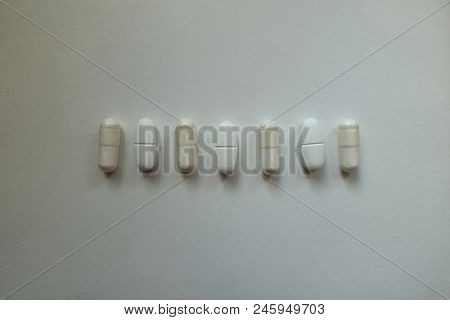 Capsules Of Magnesium Citrate And Caplets Of Calcium Citrate In A Row From Above