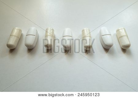 Line Of White Capsules Of Magnesium Citrate And Caplets Of Calcium Citrate