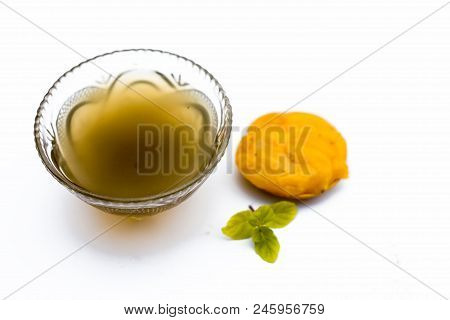 Jaggery Or Gud With Its Syrup In A Transparent Bowl Isolated On White.