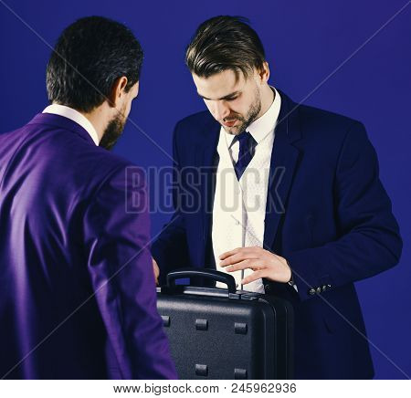 Men In Suit Or Businessmen Meet For Handover Of Black Briefcase. Business Partners With Busy Face On