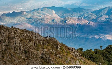 The Tourists Are On The Cliff  And Mountain Background. Green Forest At Chiangdao Mountain,chiangmai