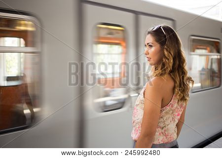 Beautiful Woman Waiting For The Subway At A Trainstation While Looking Thoughtful
