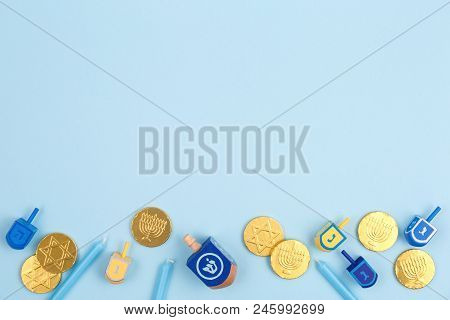 Blue Background With Multicolor Dreidels, Menora Candles And Chocolate Coins. Hanukkah And Judaic Ho