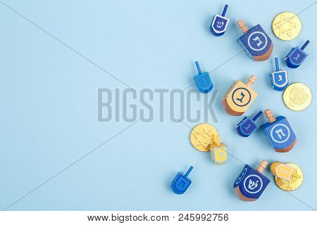 Blue Background With Multicolor Dreidels, Menora Candles And Chocolate Coins. Hanukkah And Judaic Ho