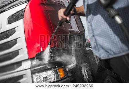 Trucker Washing His Semi Truck Using High Pressured Water Jet Cleaner.