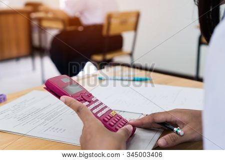 Evaluation Or Measurement Concept. Student Using Calculator For Used Making Mathematical Calculation