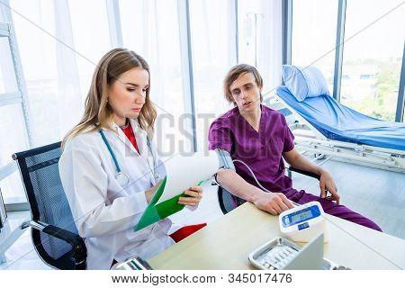 Female Doctor Therapeutic Advising With Positive Emotions To A Man Patient On Bed With Digital Press