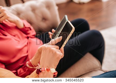 Close Up Of Wmans Hands Holding A Smartphone