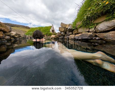 Woman Bathing And Relaxing In A Hot Spring Pool In Hrunalaug, Iceland