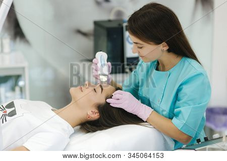 Female At Cosmetic Beauty Spa Clinic Has Facial Hardware Cosmetology. Woman Making Beauty Procedures