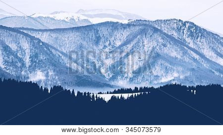 Mountain Range With Visible Silhouettes Through The Morning Colorful Fog.tarcu Mountains In Romania.