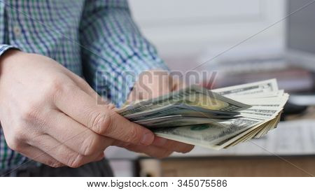 Male Hands Count Cash Money In The Office. Close Up Of Man Hands Count Dollar Bills. Starting Invest