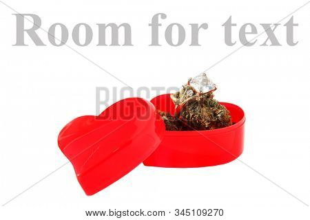 Wedding or Engagement Ring with Marijuana in a Heart Shaped Ring Box. Isolated on white. Room for text. Some people love Cannabis and Diamond Rings. Cannabis Weddings are a new trend in the USA. 