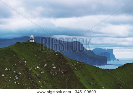 Panorama with Kallur lighthouse on green hills of Kalsoy island, Faroe islands, Denmark. Landscape photography