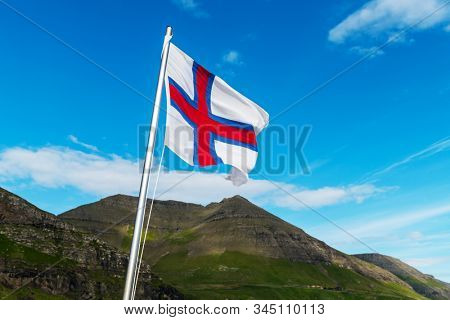 Flag of Faroe islands waving against a cloudy sky