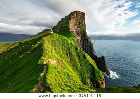 Kallur lighthouse on green hills of Kalsoy island, Faroe islands, Denmark. Landscape photography