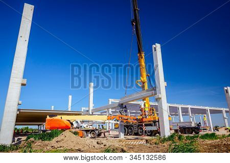 Mobile Crane Is Operating And Worker Is Assembly Concrete Joist In High Place. Height Worker Is Plac
