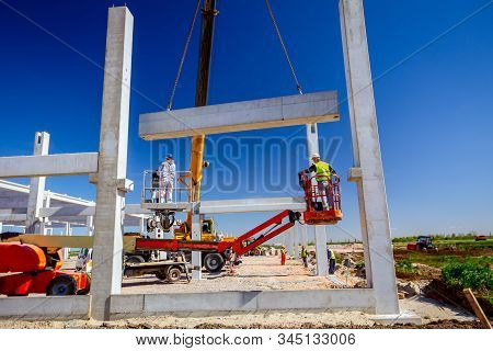 Mobile Crane Is Operating And Worker Is Assembly Concrete Joist In High Place. Height Worker Is Plac