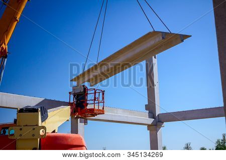 Mobile Crane Is Operating And Worker Is Assembly Concrete Joist In High Place. Height Worker Is Plac