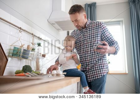 Cute Little Girl In A White Shirt Sitting On The Table