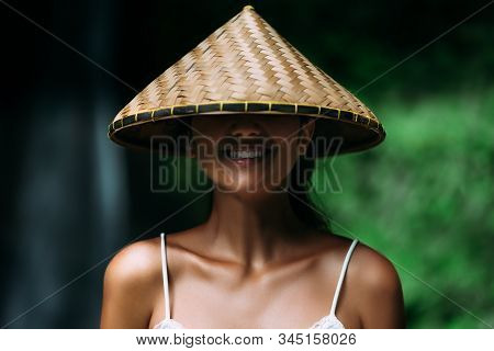 Portrait Of A Beautiful Girl In An Asian Conical Hat. Portrait Of A Smiling Girl. Beautiful Smile. C