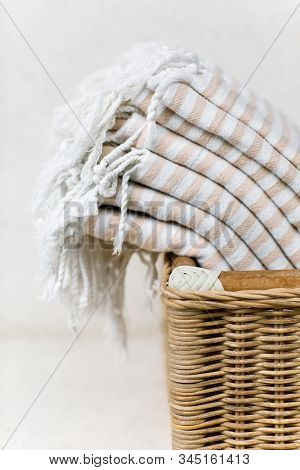 White Stripe Cotton Bath Towels Lying In Whicker Basket On White Background. Organic Pestemal Towels