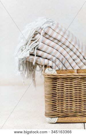 White Stripe Cotton Bath Towels Lying In Whicker Basket On White Background. Organic Pestemal Towels